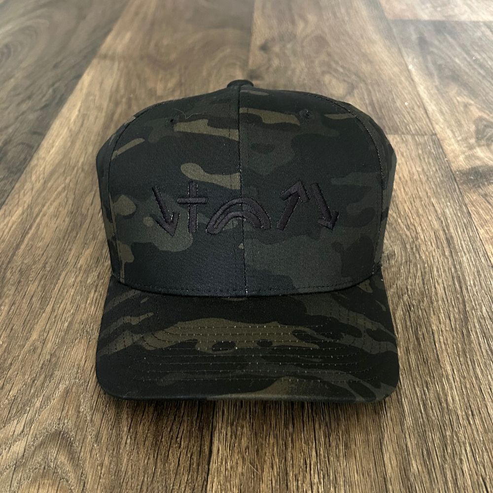 Black camouflage cap with a logo on a wooden surface