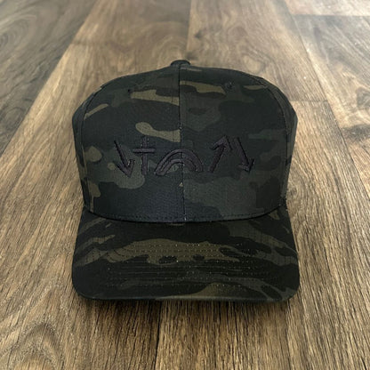 Black camouflage cap with a logo on a wooden surface