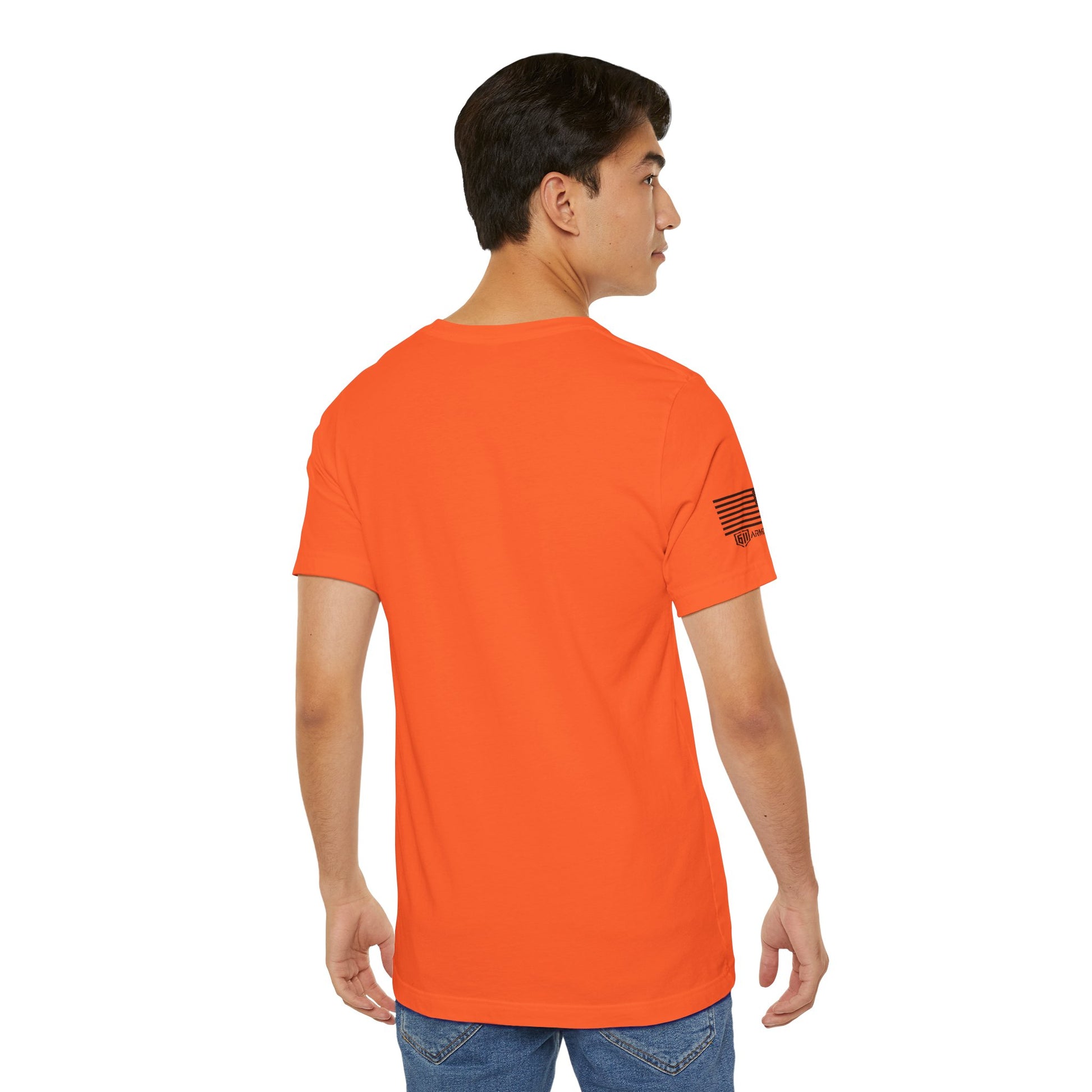 Person wearing an orange t-shirt with a small flag design on the sleeve against a white background