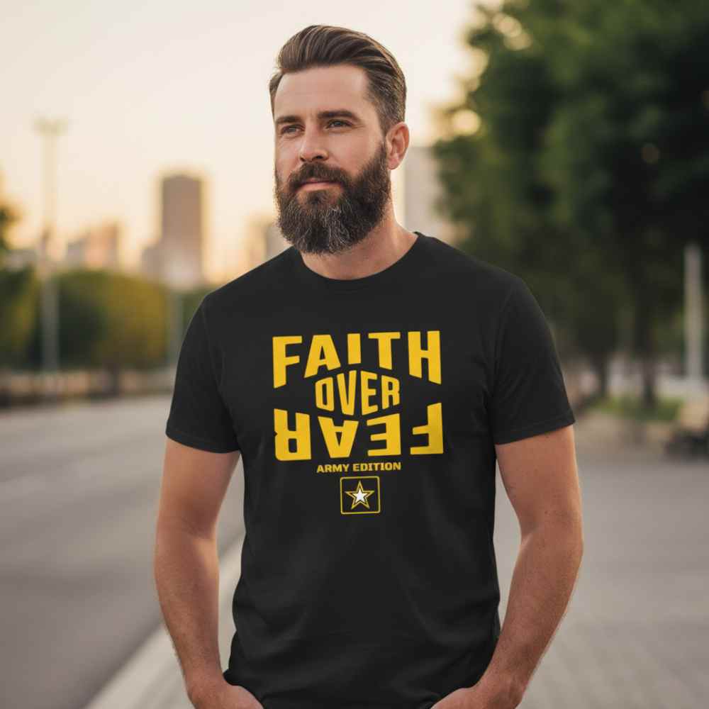 Man wearing a black t-shirt with 'Faith Over Fear' text in yellow outdoors.