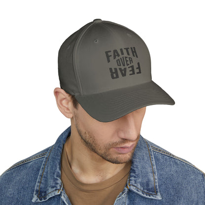 Man wearing a gray cap with 'Faith Over Fear' text on a white background