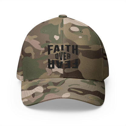 Camouflage baseball cap with 'Faith Over Fear' text on a white background