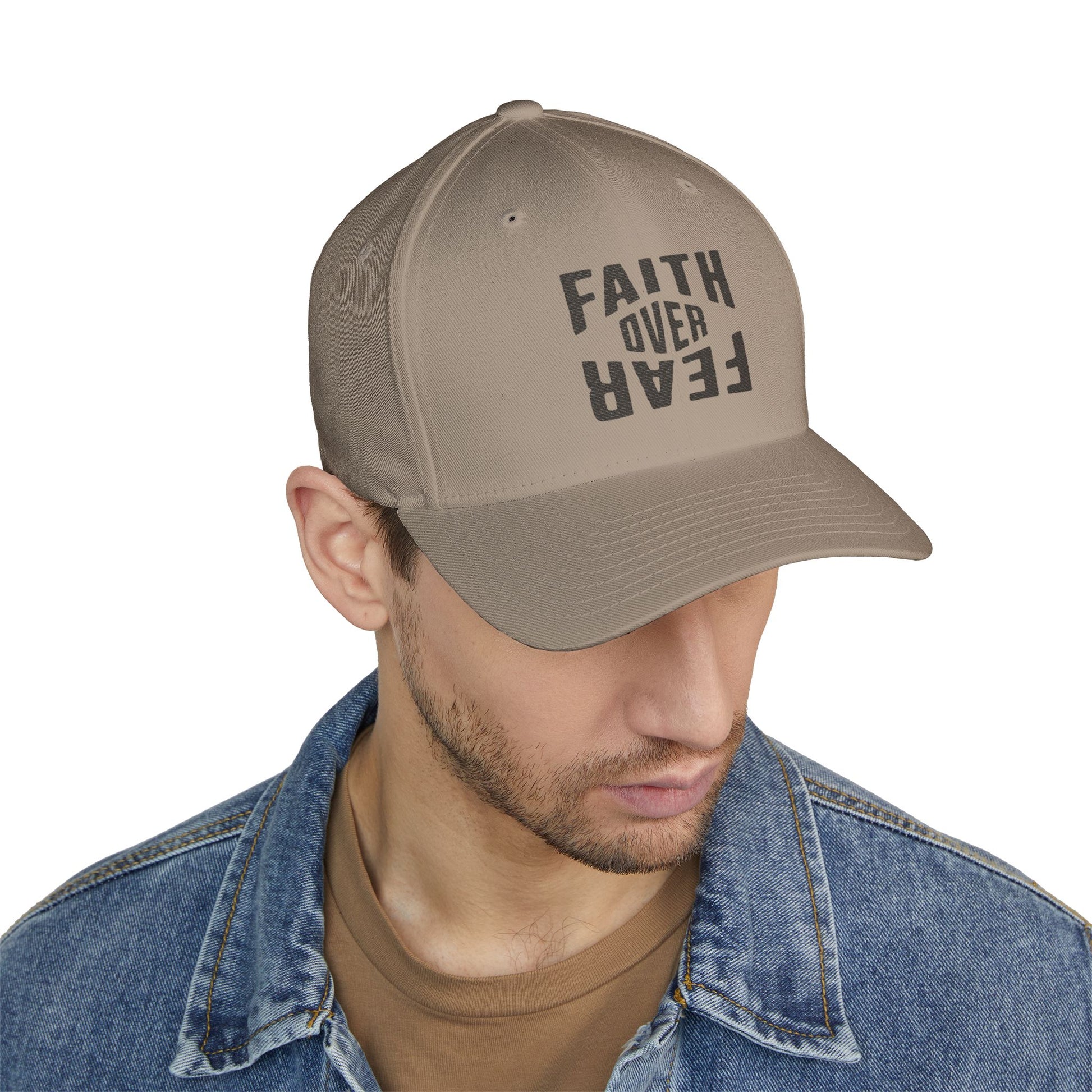 Man wearing a beige cap with 'Faith Over Fear' text on a white background