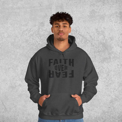 Person wearing a dark gray hoodie with 'Faith Over Fear' text on a textured gray background