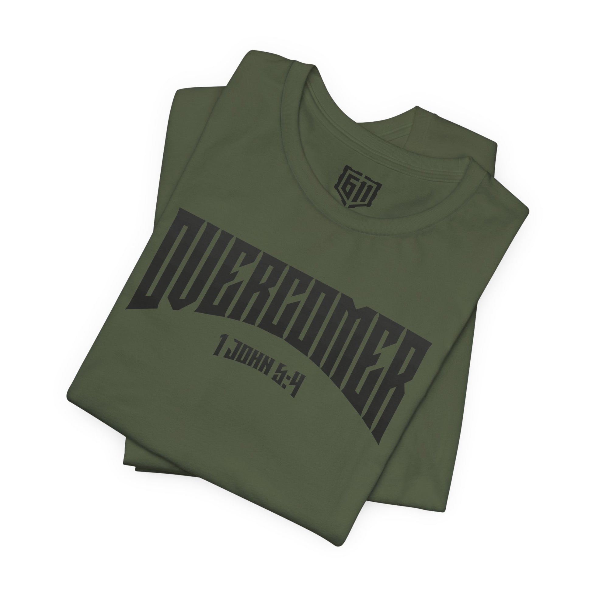 Folded green t-shirt with 'OVERCOMER' text on a white background