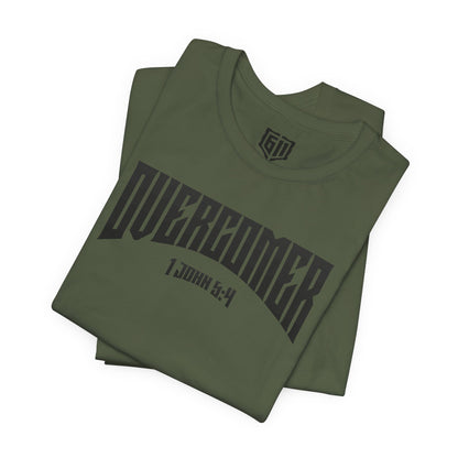 Folded green t-shirt with 'OVERCOMER' text on a white background